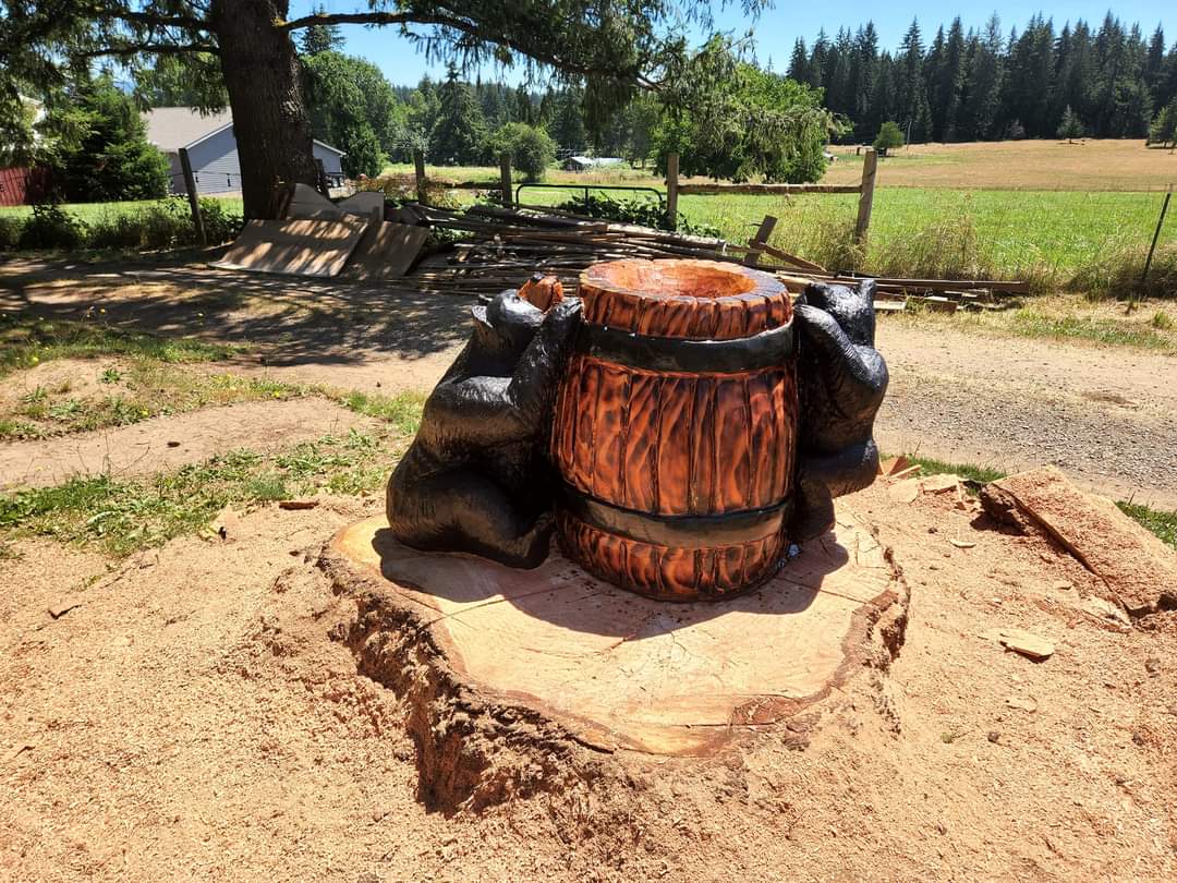 Doug fir stump carve of mama and cub with a whiskey barrel flower pot